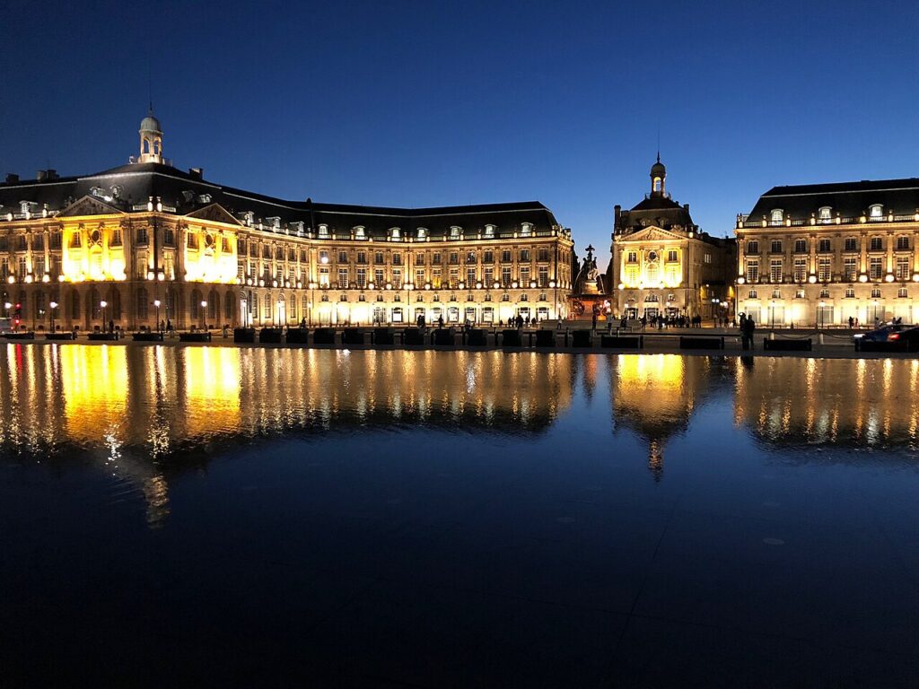 La place de la Bourse à Bordeaux illuminée et reflétée dans le miroir d’eau