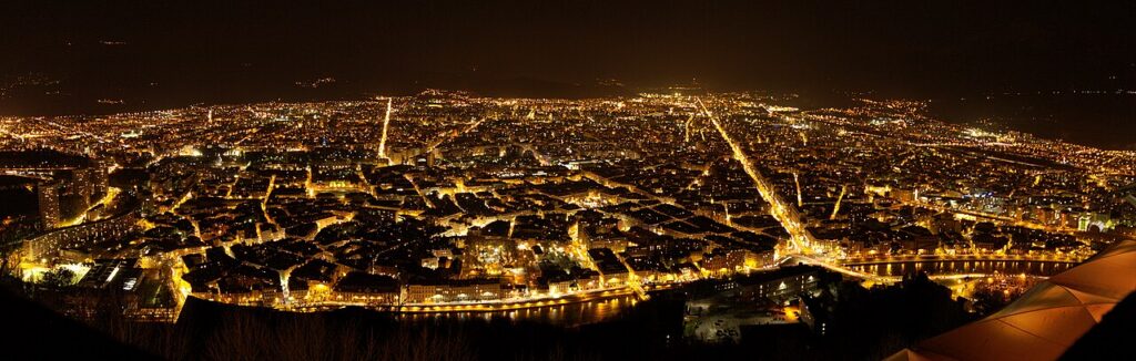 Grenoble et ses montagnes à la tombée de la nuit, vus depuis la Bastille