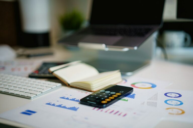 Documents chiffrés, calculatrice et carnet sur un bureau