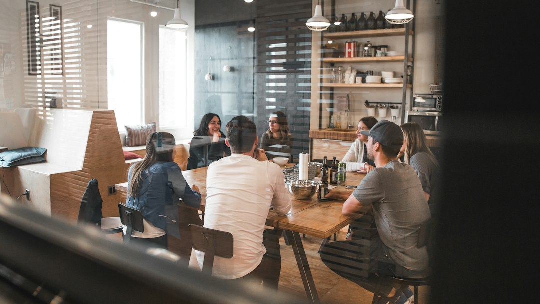 Un groupe échange autour d’une table dans une salle de réunion