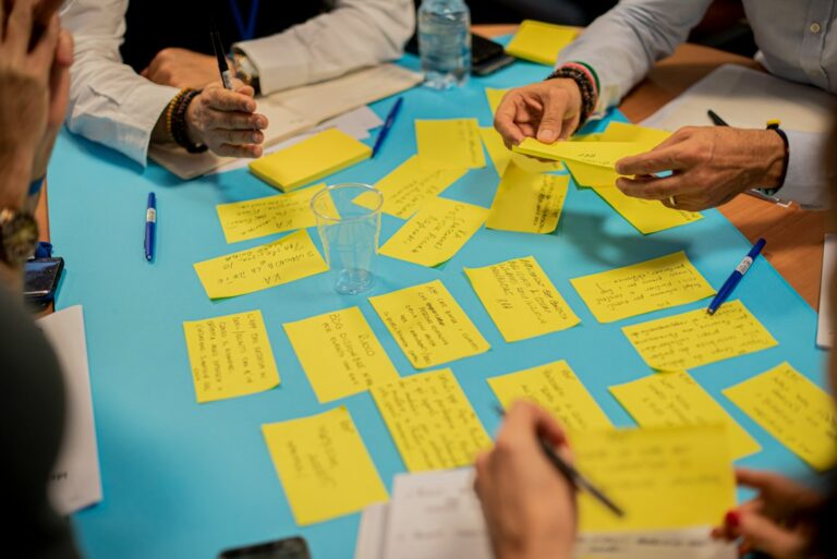 Des participants organisent leurs idées sur des notes adhésives autour d’une table
